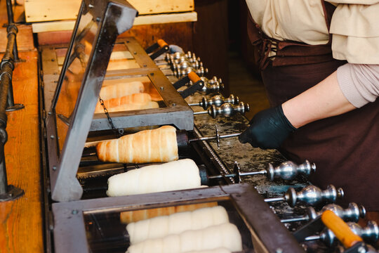 Trdelnik or trdlo on a stall, it's spit cake made from rolled dough  wrapped around a stall grilled and topped with sugar and walnut mix, chimney cake. Iconic street food from Prague, Czech Republic