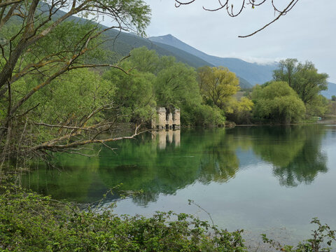 Ancient Stone Ruins Reflected in the Crystal Clear Emerald Waters of Capodacqua Lake in Capestrano, Abruzzo, Italy