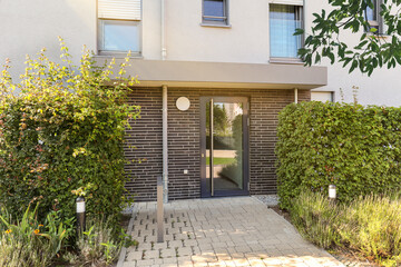 View to entrance door of a modern residential building with new apartments in the city © ah_fotobox
