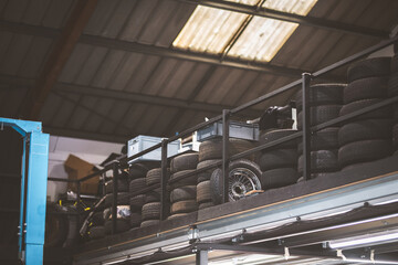 Tire storage in a workshop with a blue car lift and skylights © Pavel Babic