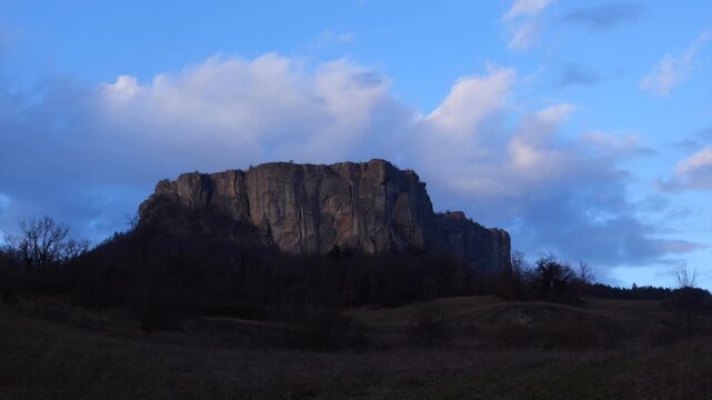 Time lapse video of the Pietra of Bismantova at sunset with a cloudy sky. Castelnuovo Monti, Reggio Emilia, Italy