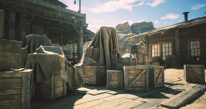 In a rustic settlement, wooden crates are stacked and covered with draped fabric. The bright sunlight casts shadows around the buildings, creating a picturesque landscape.