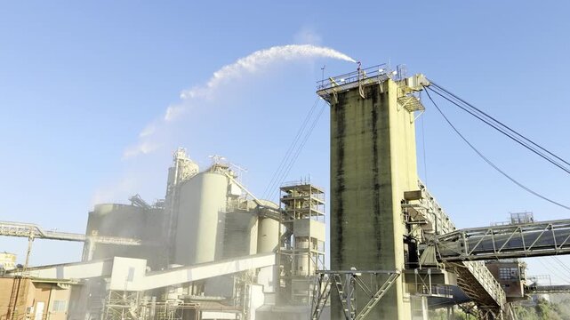 Powerful mechanical loading arm dispensing millions of seeds deep into the hold of an international shipping tanker at a sunny coastal terminal.