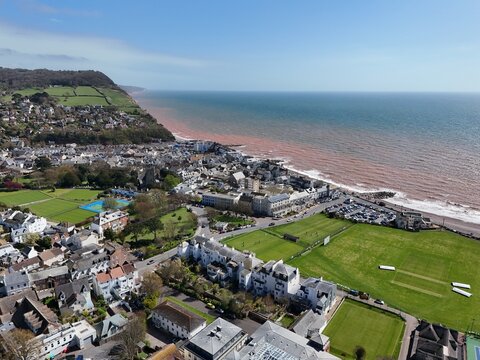 Sidmouth Devon coastline and town establishing aerial shot  looking  out to sea