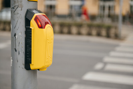 Pedestrian crossing button installed at street corner to assist city dwellers with safe crossing. Modern infrastructure reflects transport needs in urban areas