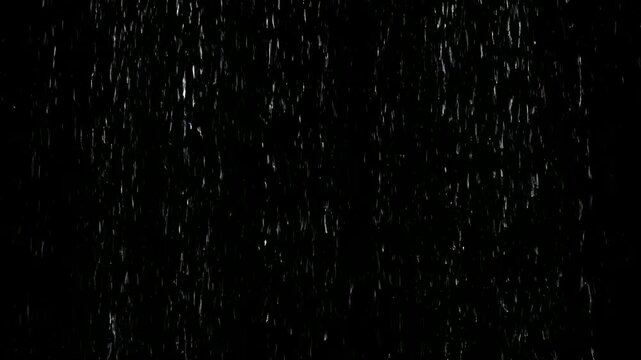 Heavy white rain drops falling vertically with black isolated background