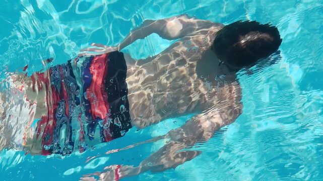 Preteen boy, child swimming in pool, enjoying water activity, summer fun, active lifestyle, healthy childhood, splashing water, outdoor leisure, Carefree childhood moment, Summer vacation fun
