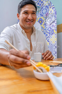 Happy man enjoying peruvian japanese fusion makis
