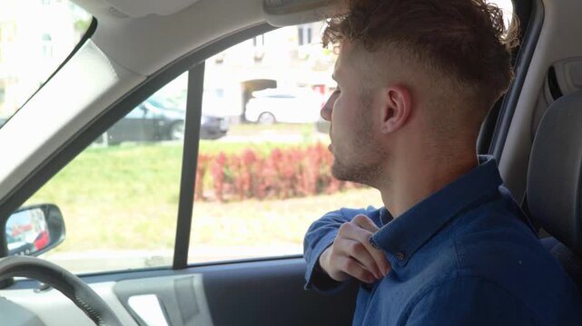 Exhausted man sitting inside car hot weather while looking on the road in the city. Right hand drive car. Lifestyle, travel, transport concept. Real time