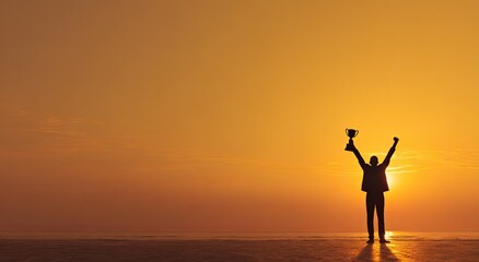 Fototapeta premium A silhouetted figure triumphantly raises a trophy against a vibrant sunset backdrop, symbolizing achievement and victory.