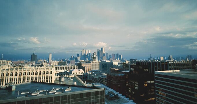 calm morning skyline above rooftop with distant skyscrapers under soft cloud cover, historic brick ledges and metal vents framing foreground, cool blue tones