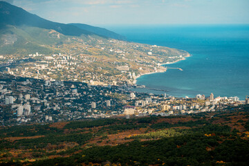 Fototapeta premium Elevated View Of Bustling Shoreline And Mountains. Aerial Shot Of Lively Coastal Town With Bay And Hills