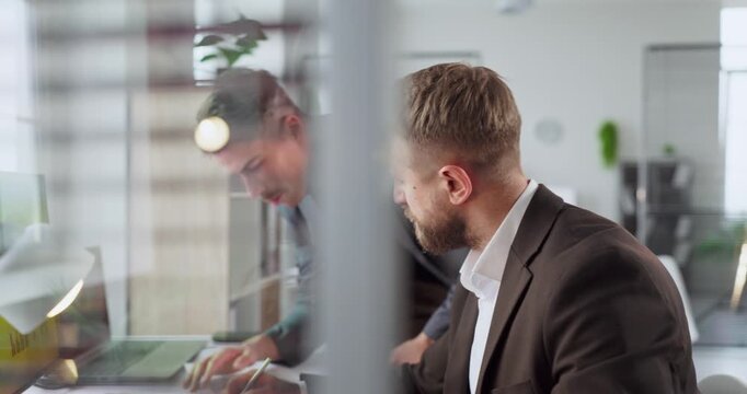 Men businessmen in office review finance analysis. They discuss strategy at a computer, examining graphs and charts for planning and decisions. Strong concept of business teamwork strategy.