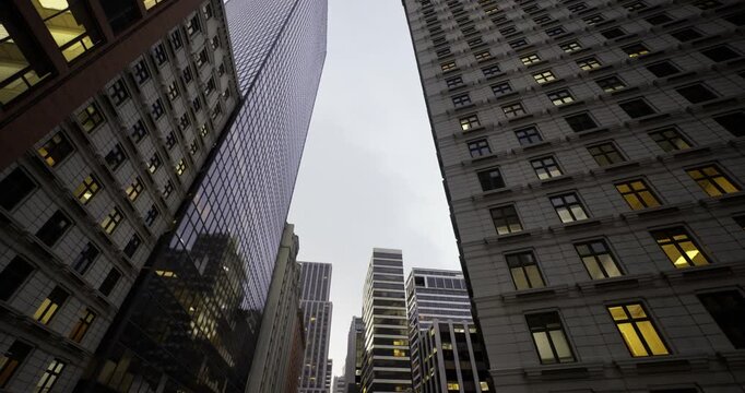 Bright office windows create warm grid on towers, Luminous office windows craft cozy grid pattern along towering city structures during nighttime