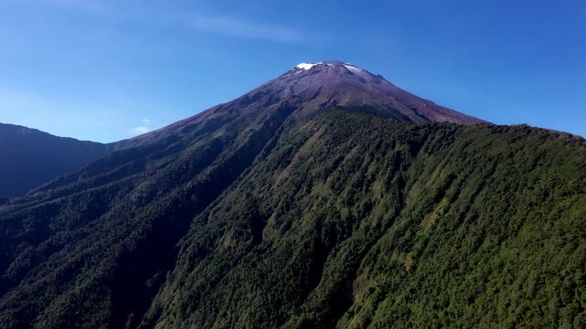 Aerial view of a mountain rigde full of trees leading to the Tungurahua volcano in the Andes of Ecuador, South America
