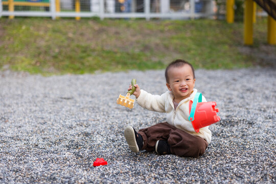 Little boy playing with stone in outdoor park