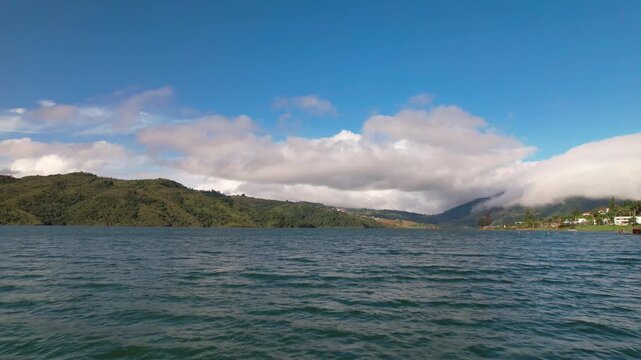Sailing on a lake with mountains and clouds