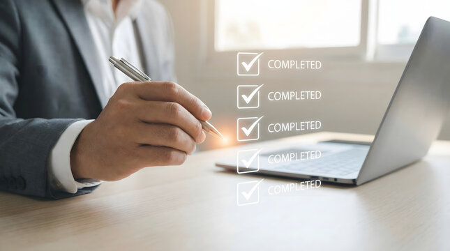 Businessman points pen at laptop screen with virtual checklist showing completed tasks in a bright office