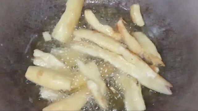 Frying crispy cassava chips in a hot pan using a classic pressure kerosene stove, village lifestyle.