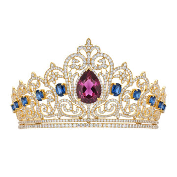 Handcrafted gold tiara with a pink sapphire and blue gems on a reflective white surface with soft studio lighting concept of royal heritage and luxury