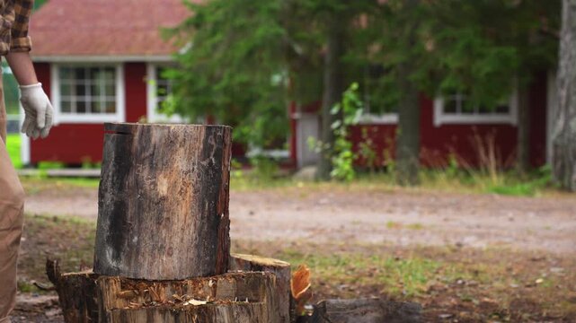 Strong man splitting a tough wooden log with an axe. Slow motion 4K ProRes 422 footage of successful manual labor