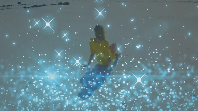 Woman with child sitting on beach, blue sparkle overlay appearing while woman shifting for health