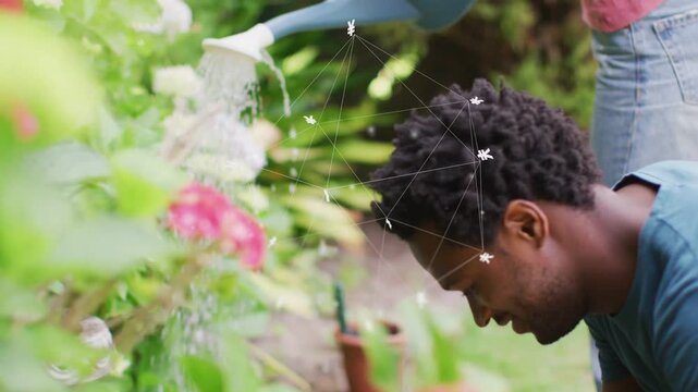 Man crouching inspecting plants in garden, overlay over head growing as partner pouring water