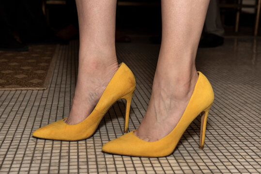 Woman standing in yellow high heels