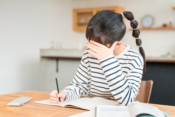 Naklejka premium Elementary, middle, and high school girls studying at home (homework, pressure, exams, studying in the living room)