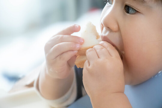パンを食べる幼児のクローズアップ（手づかみ食べ・日常の食事風景）