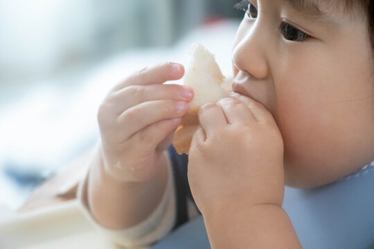 パンを食べる幼児のクローズアップ（手づかみ食べ・日常の食事風景）