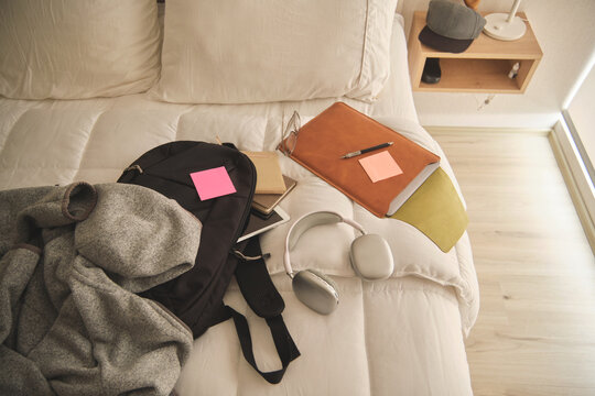 Student backpack and study essentials lying on a bed, ready for new academic challenges