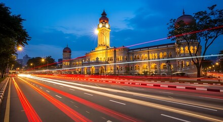 Obraz premium Illuminated building at night with traffic light trails and a clear sky