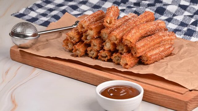 Homemade Spanish churros snack on a wooden board and a rustic background