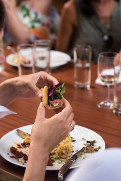 Woman Holding Taco at Dining Table