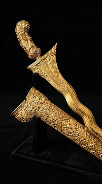 A luxurious golden sculpture inspired by the traditional keris dagger, one of Indonesia&rsquo;s most revered cultural weapons. The elegant wavy blade and intricate carvings represent spiritual power and roy