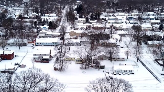 Winter blanket settles over Trumbull Connecticut neighborhood covered in snow - aerial flyover on a cold winter day