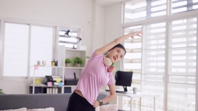 Asian adult woman stretch exercise home living room promoting fitness wellness flexibility healthy lifestyle active morning routine