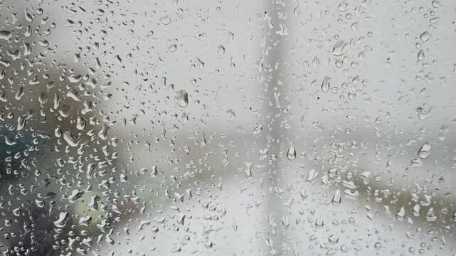Rainy windshield shows distant lights. Rainsoaked windshield creates blurred scenery with distant bright spots. This scene captures rainy car journey with blurry road and shining distant lights
