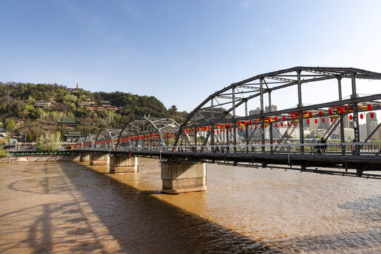 The charming spring scenery of Zhongshan Bridge over the Yellow River in Lanzhou displays a vibrant and picturesque view