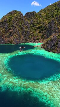 Aerial drone view of coral reef and turquoise waters at Twin Lagoon, Coron, Palawan, Philippines. Tropical lagoon with limestone cliffs and clear blue sea.