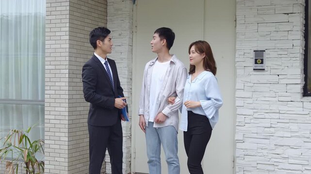 Welcoming new homeowner, salesperson real estate realtor introduces clients couple to new living space holding a clipboard with essential documents, discussing contract terms