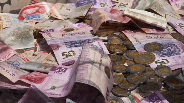 Traditional Mexican bimetallic coins scattered with banknotes