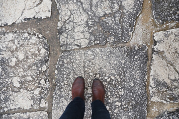 Person stands on cracked stone pavement underfoot © Towfiqu Barbhuiya 