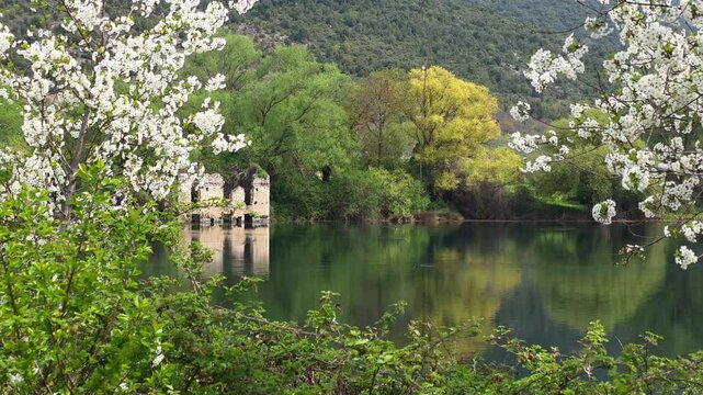 Ancient Stone Ruins Reflected in the Crystal Clear Emerald Waters of Capodacqua Lake in Capestrano, Abruzzo, Italy