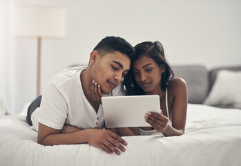 Fototapeta premium Love, relax and tablet with couple in bedroom of home together for bonding or break. App, comfortable and relationship with people on bed in apartment for morning, weekend streaming or wellness