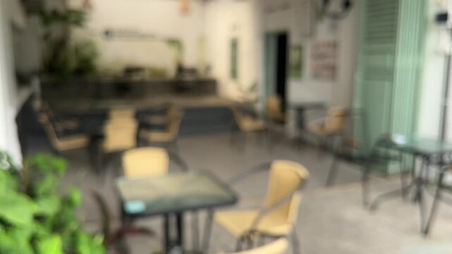 Exterior of cafe, coffee shop or restaurant. empty glass tables and chairs. white wall. dining, dine in. old. rattan. classic, old, vintage, history, historical. outdoor. bakery. blur, blurred, blurry