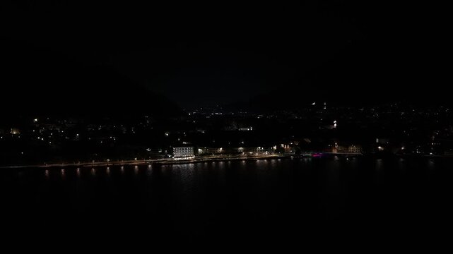 Malgrate, Lombardy, Italy - The Night View Reveals a Serene Waterfront, Illuminated by Streetlights Reflecting Off the Calm Water - Drone Flying Forward