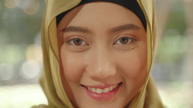 Close-up portrait of a young Muslim woman in hijab smiling warmly, representing confidence, identity, and positive lifestyle.
