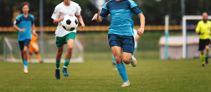 Youth Soccer Match Action; Kids Running and Competing for Ball During Football Game on Field